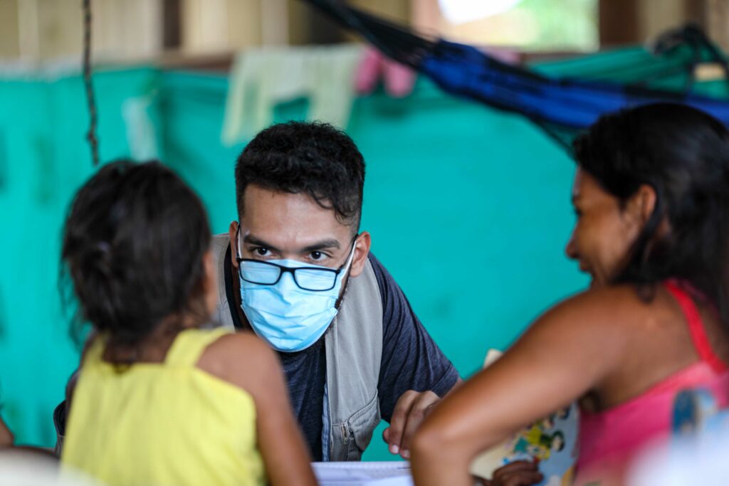 Mann mit Atemschutzmaske, der ein Kind auf COVID-19 testet