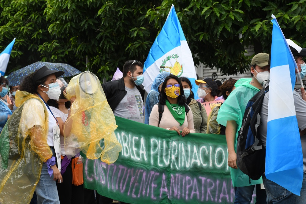 Demonstrant*innen mit Transparent und Guatemala-Flaggen
