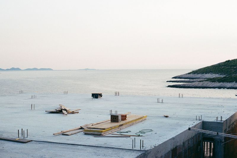 Baustelle bei Sonnenuntergang, dahinter das Meer.